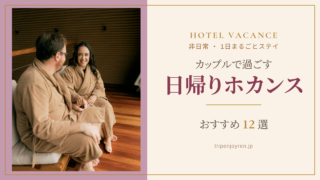 バスローブ姿のカップルが、ホテルの客室で向かい合ってくつろぎながら日帰りホカンスを楽しむ様子